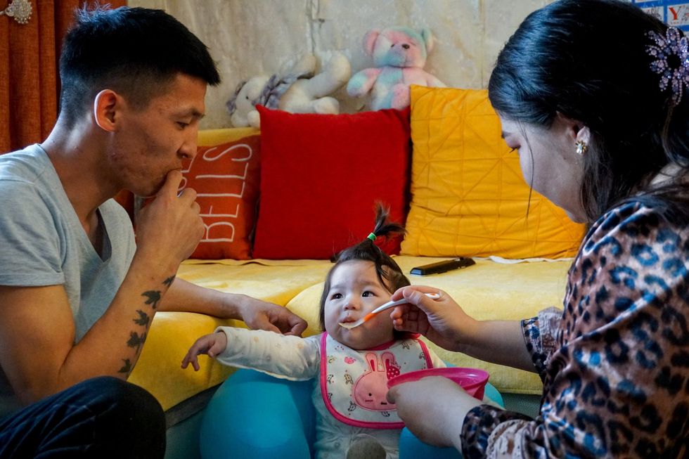 Image of a man and woman feeding their baby