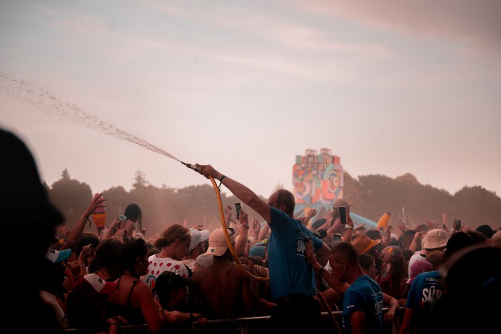 Image of a man refreshing people in a crowd during a heatwave.