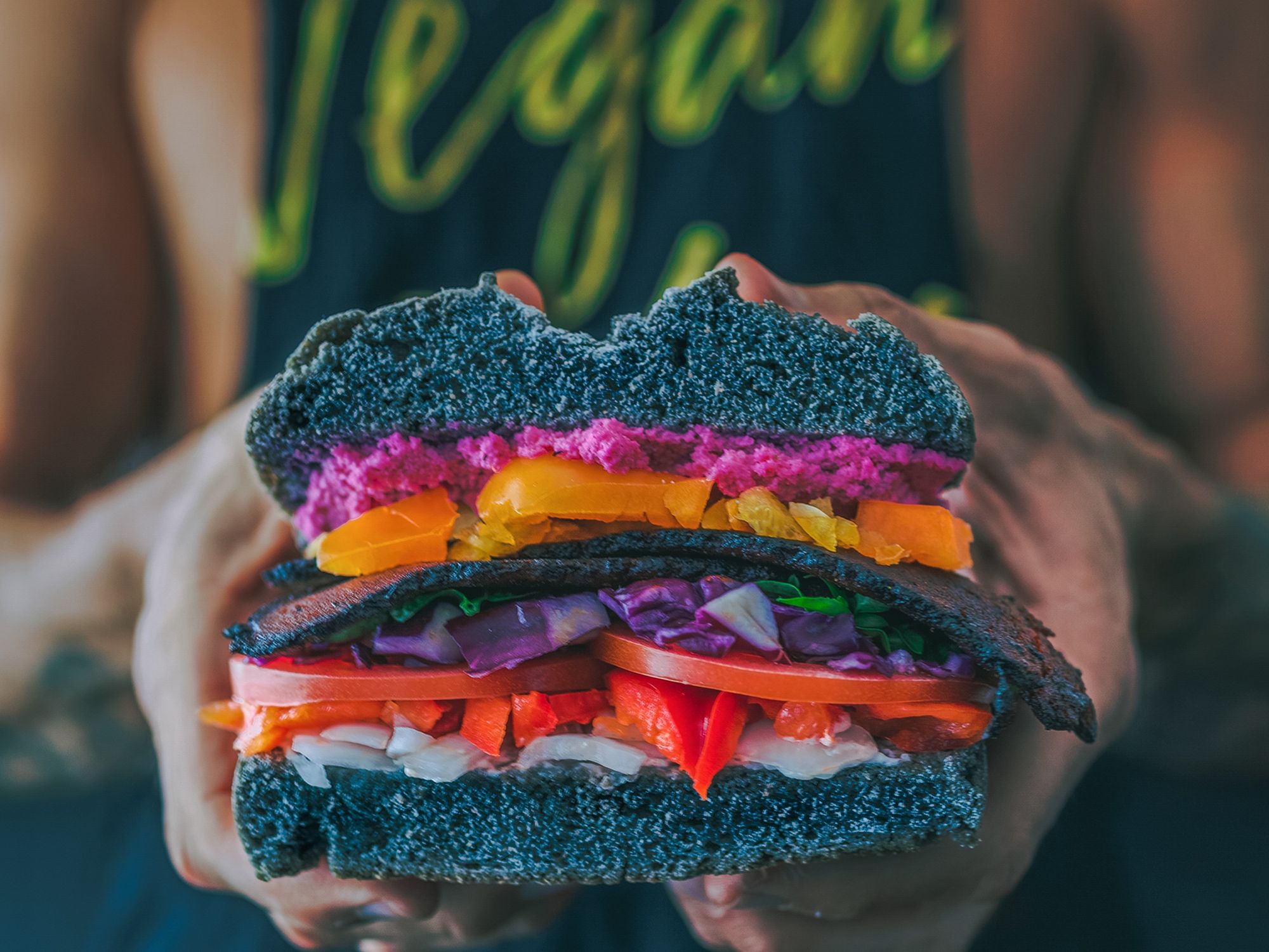 Image of a person holding a colorful veggie burger.