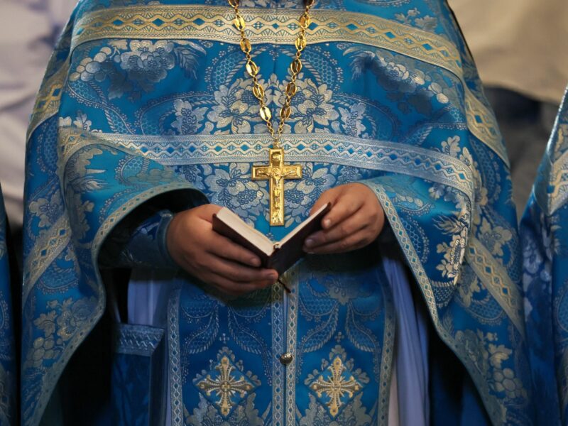 image of a priest holding a prayer book