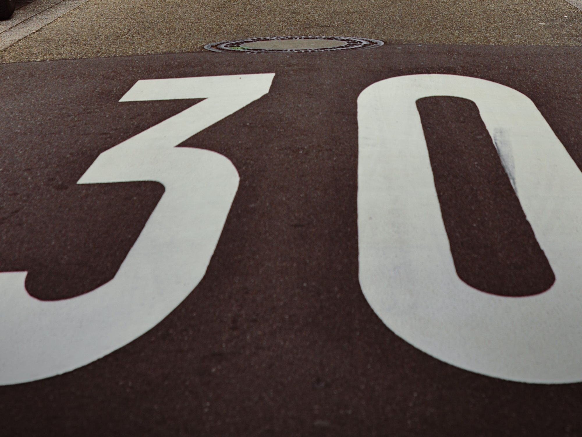 Image of a sign on a road indicating the speed limit.