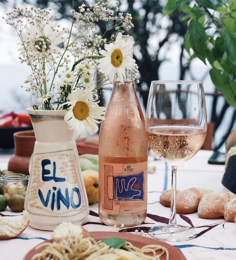 Image of a table with a bottle of El Vino and food.