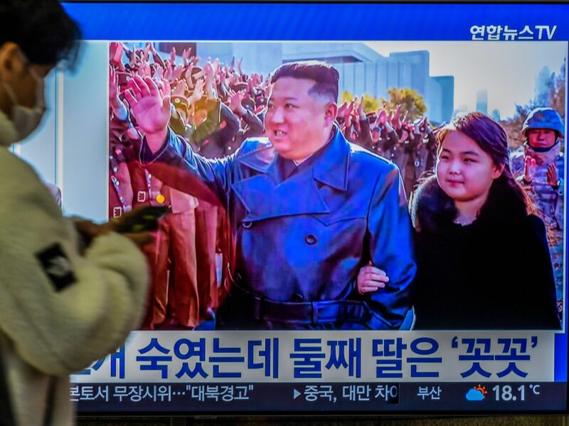 Image of a TV screen with North Korean leader Kim Jong-Un's second public appearance with his daughter during a photo session with officials when intercontinental ballistic missile