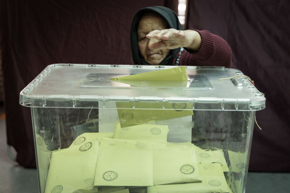 Image of a woman casting her ballot at a polling station in Istanbul, Turkey.