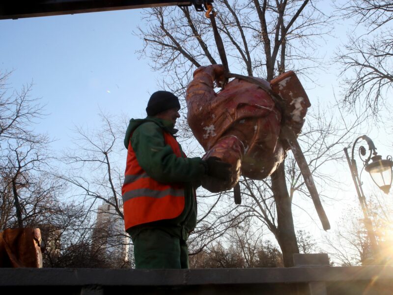 Image of a worker dismantling the statue of a Soviet war hero in Kyiv