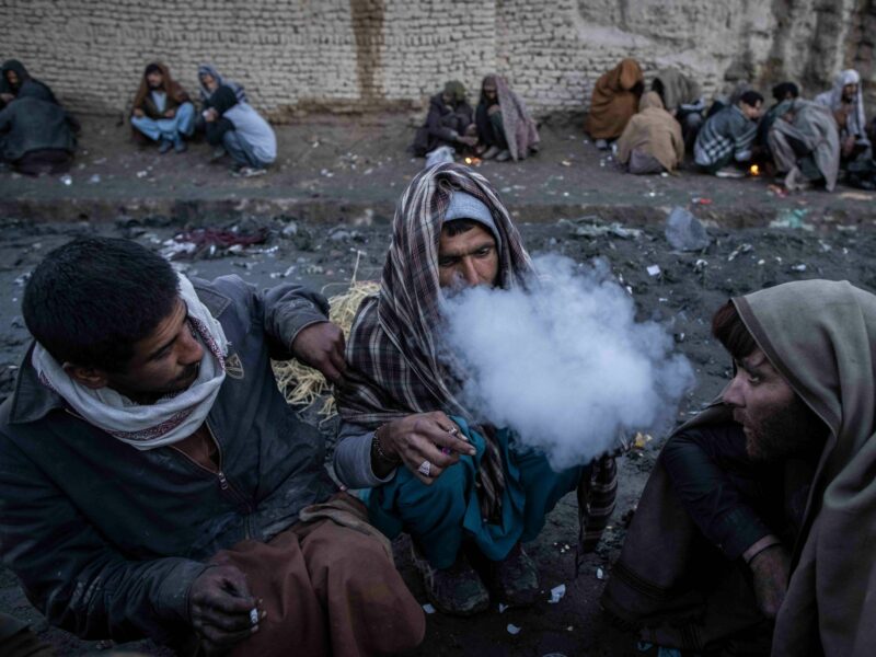 Image of Afghan men consuming drugs on a street in Kabul.