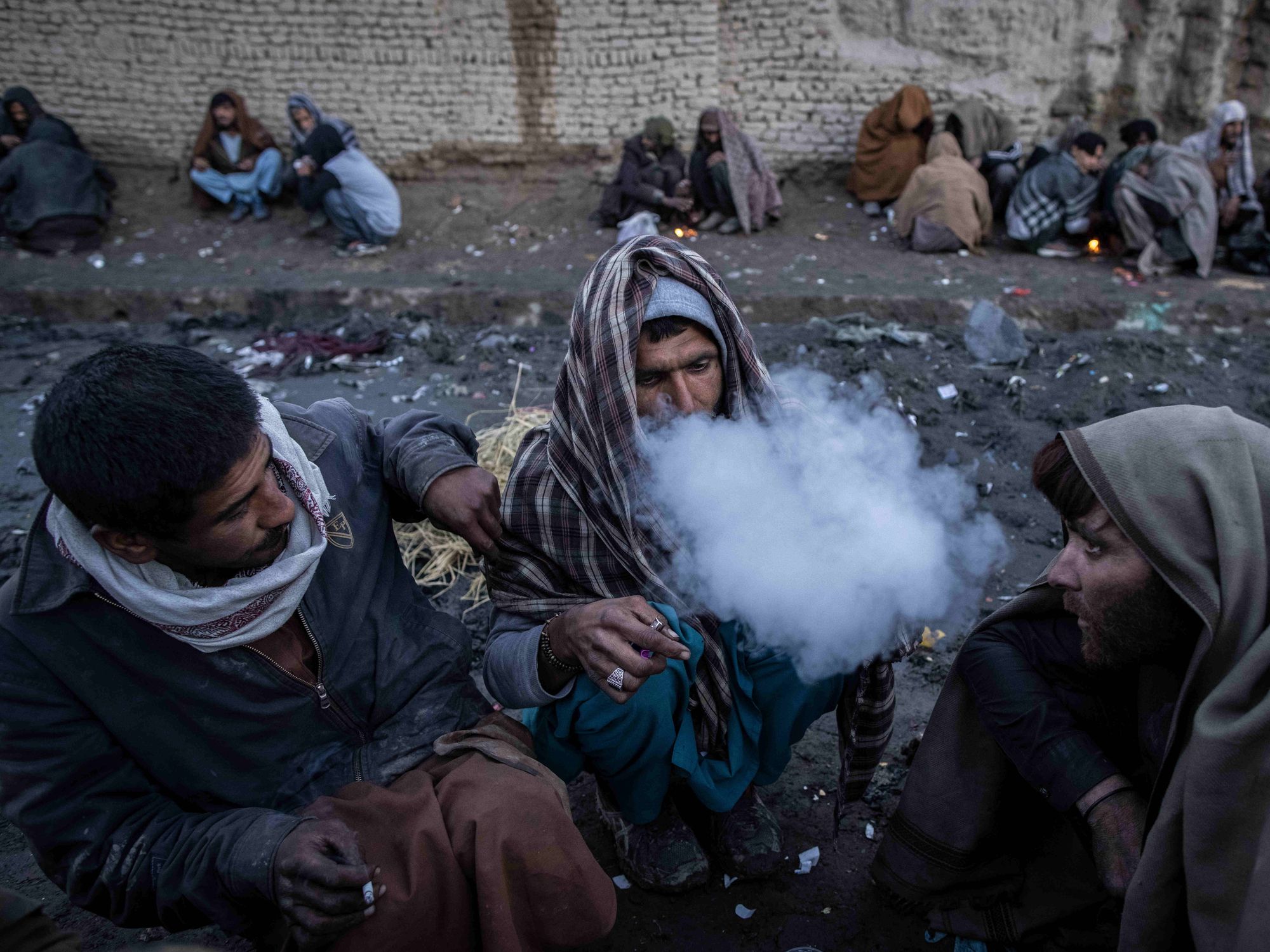 Image of Afghan men consuming drugs on a street in Kabul.