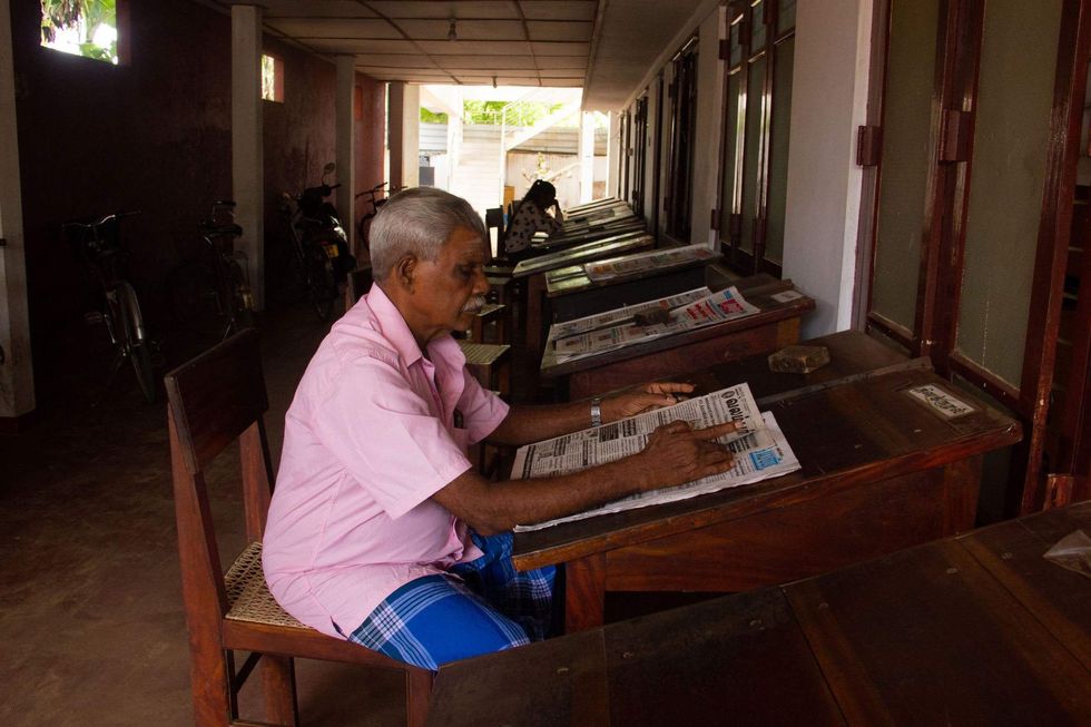 Image of an elderly man reading a newspaper