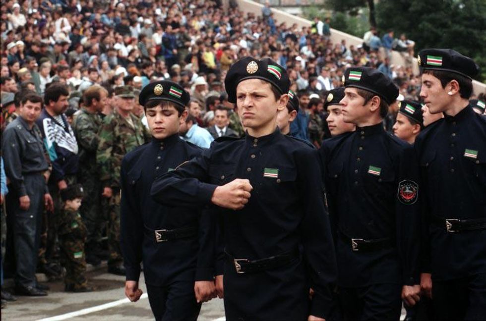 Image of Chechen cadets in their navy uniform with Chechen flags on their caps marching, in 1999.