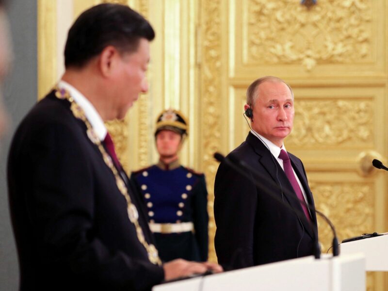 Image of Chinese President Xi Jinping and Russian President Vladimir Putin standing next to each other during a ceremony at the Moscow Kremlin.