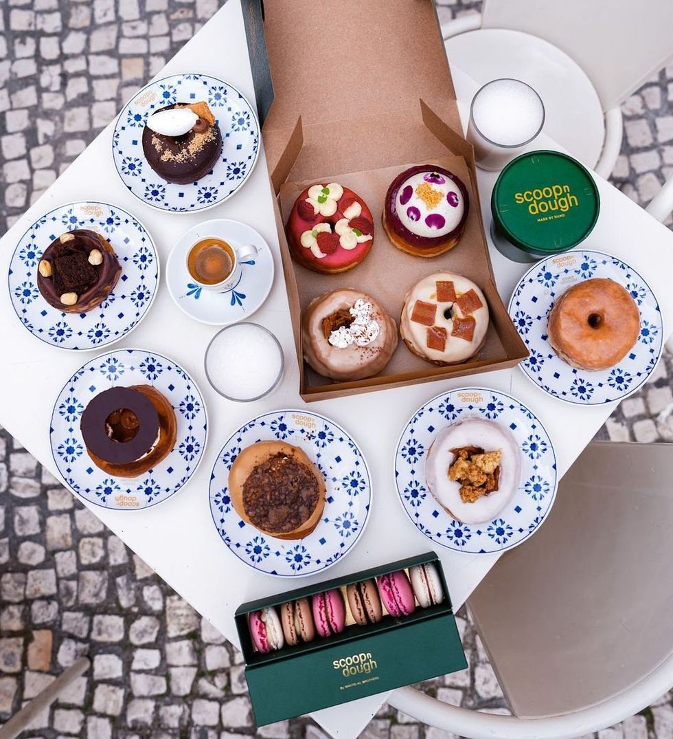 Image of donuts and macaroons on a table outside.