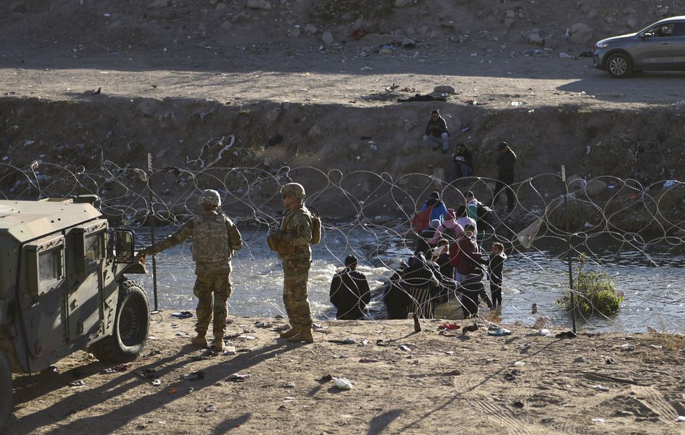 Image of ​Migrants seeking asylum deterred after receiving instructions from members of the Texas National Guard and Texas Department of Public Safety along the U.S. Mexico border in El Paso, Texas.