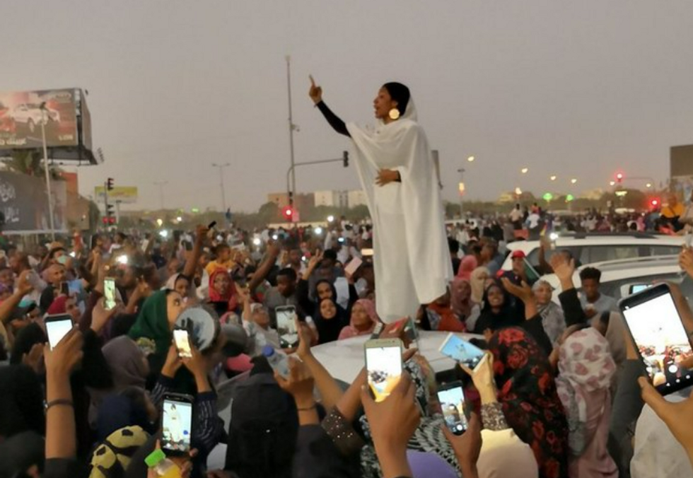 Image of “Kandaka,” or Nubian queen, talking to a crowd during a protest in Sudan.