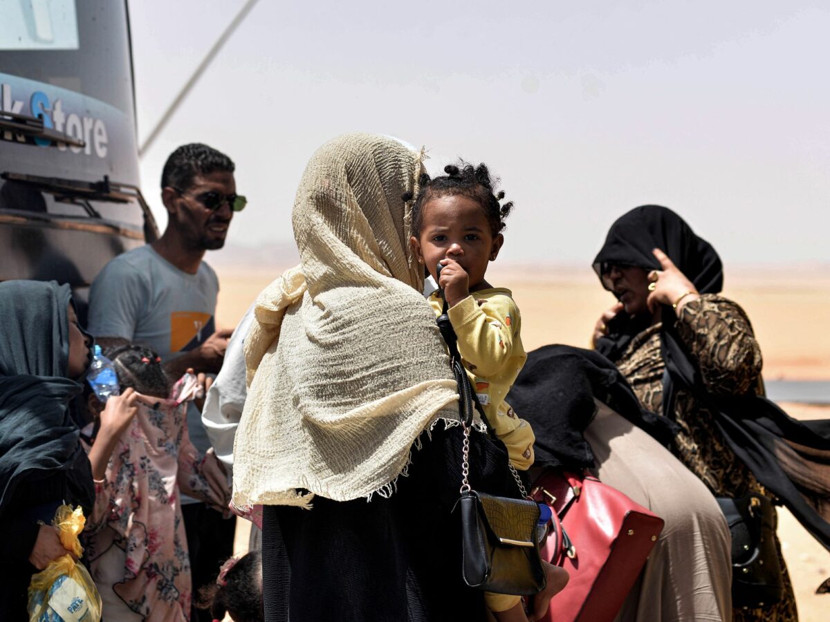 Image of families of Sudanese refugees with their children, arriving into Egypt.