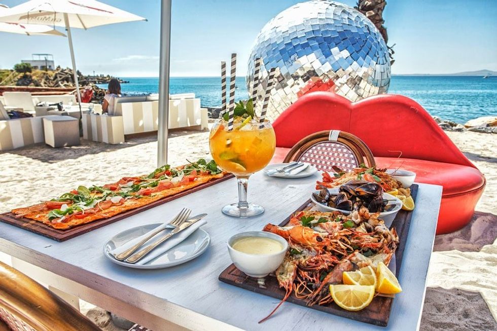 Image of food platters and a giant cocktail on the beach
