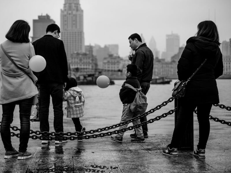 Image of four adults and two children walking by the water in Shanghai