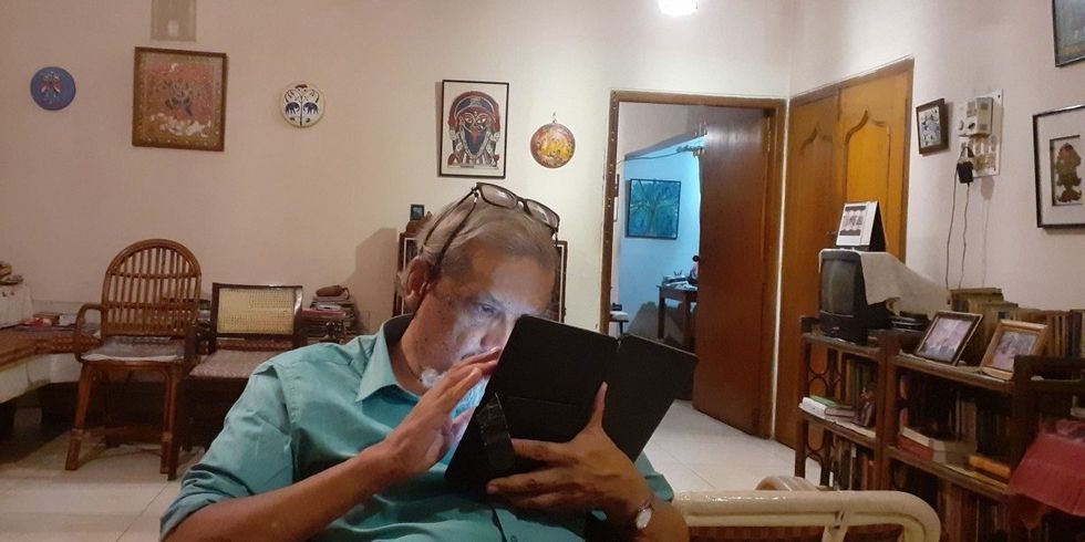 Image of Hari Vasudevan in his home, using a tablet, in 2019.