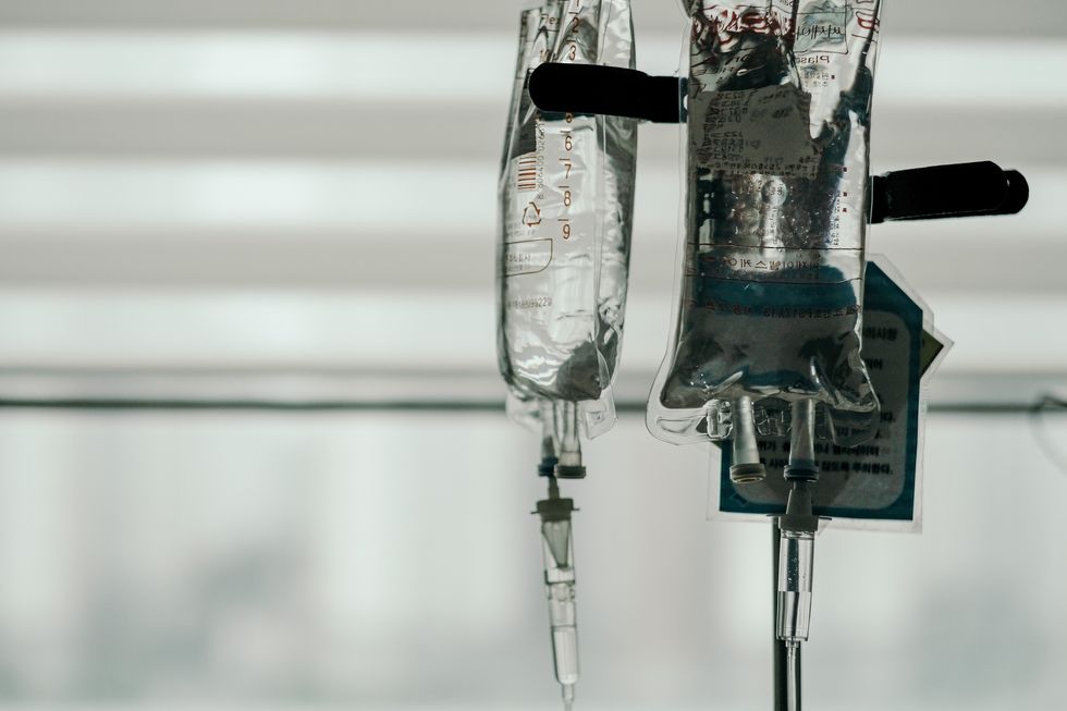 Image of IV bags full of liquid in a hospital room.