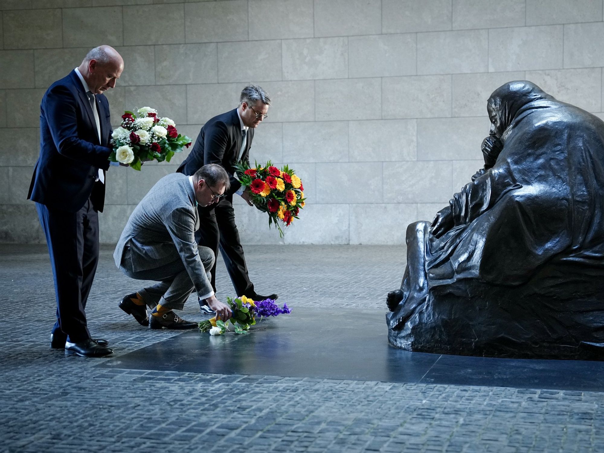 Image of Kai Wegner, Berlin's Governing Mayor, Olekseii Makelev, Ambassador of Ukraine to Germany, and Tobias Linder, Minister of State at the Federal Foreign Office, laying flowers in commemoration of the end of World War II.