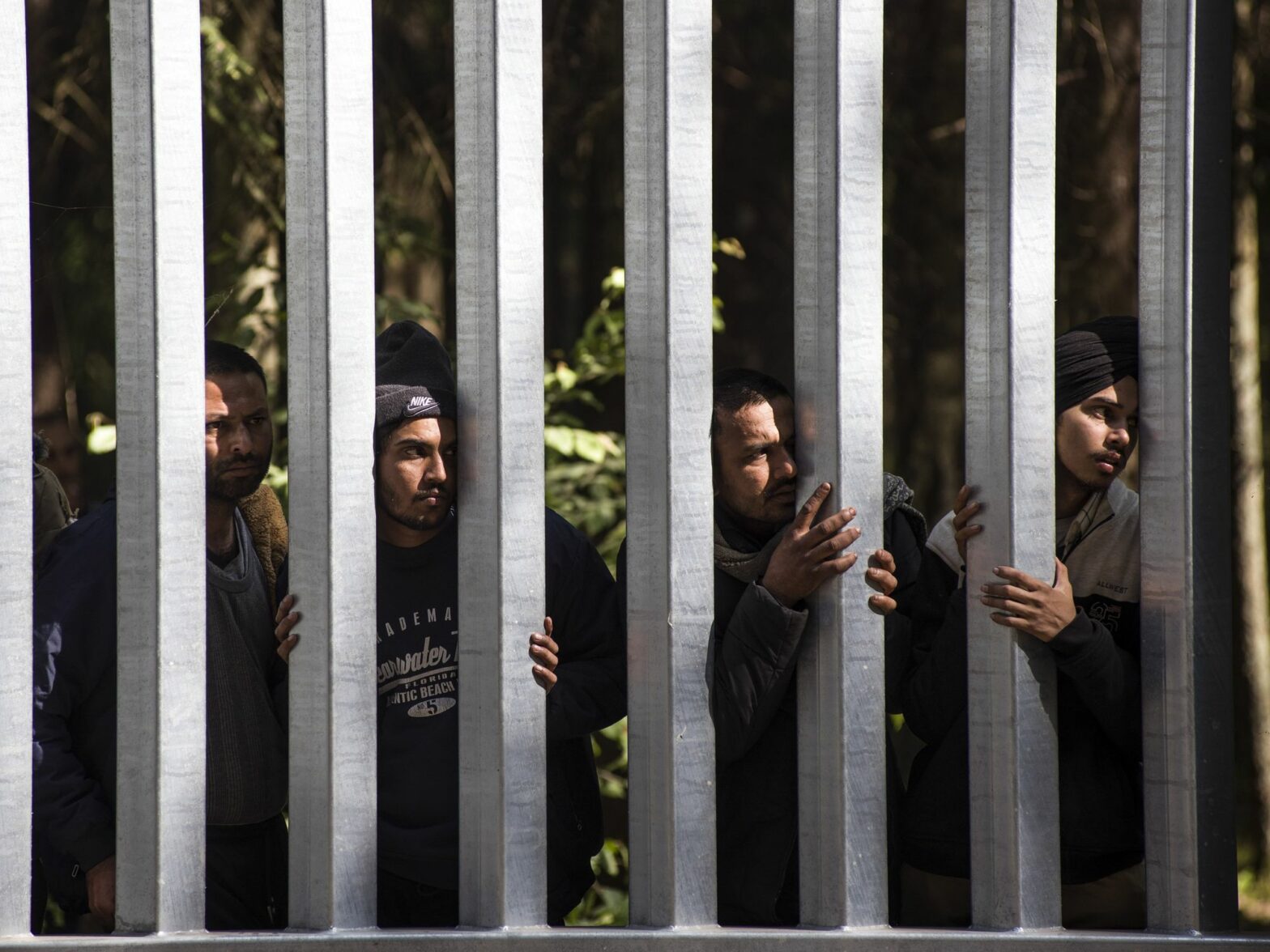 Image of migrants with children seeking asylum at the Belarusian side of the Polish border wall in Bialowieza, Podlaskie, Poland.
