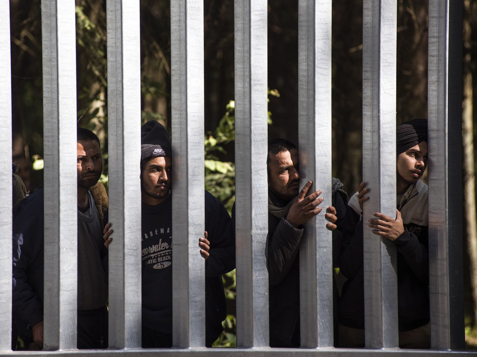 Image of migrants with children seeking asylum at the Belarusian side of the Polish border wall in Bialowieza, Podlaskie, Poland.