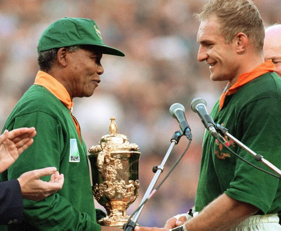image of nelson Mandela and a rugby player holding a trophy