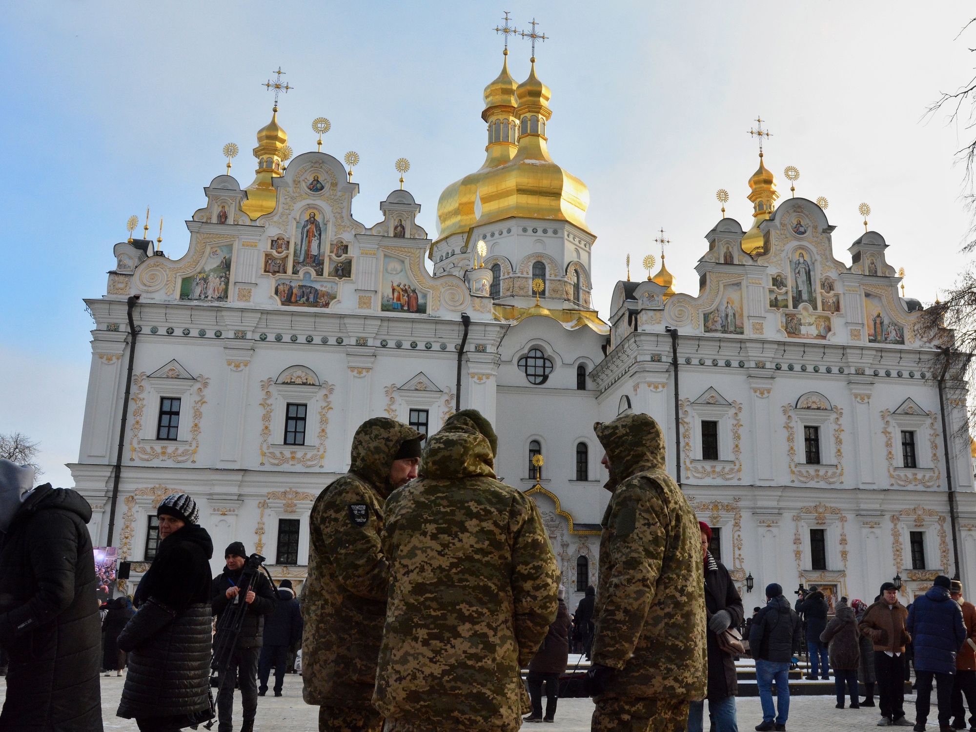 Image of people and soldiers in the foreground standing against the background of the Assumption Cathedral during the Christmas service, which was led by the Metropolitan Epiphany of the Orthodox Church of Ukraine.