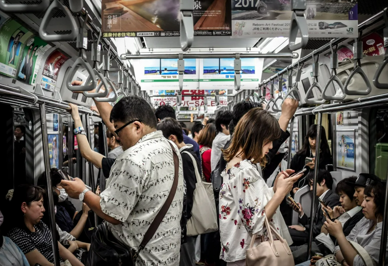 Image of people checking their phone on the subway.