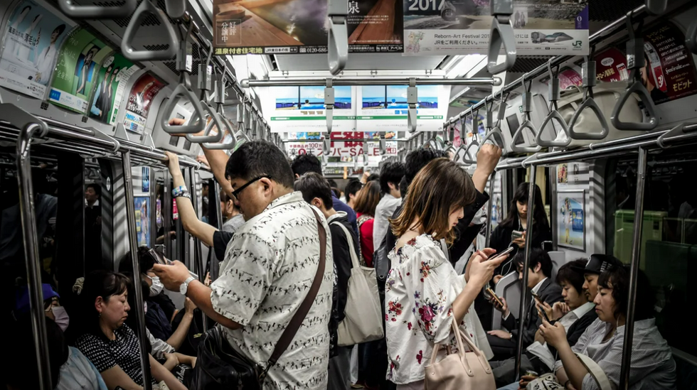 Image of people checking their phone on the subway.