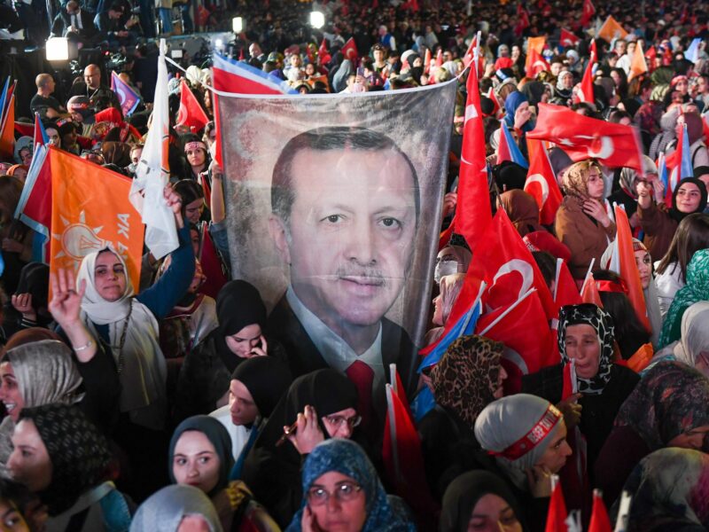 Image of people holding a flag with Erdogan's face on it during a protest in Ankara, Turkey.