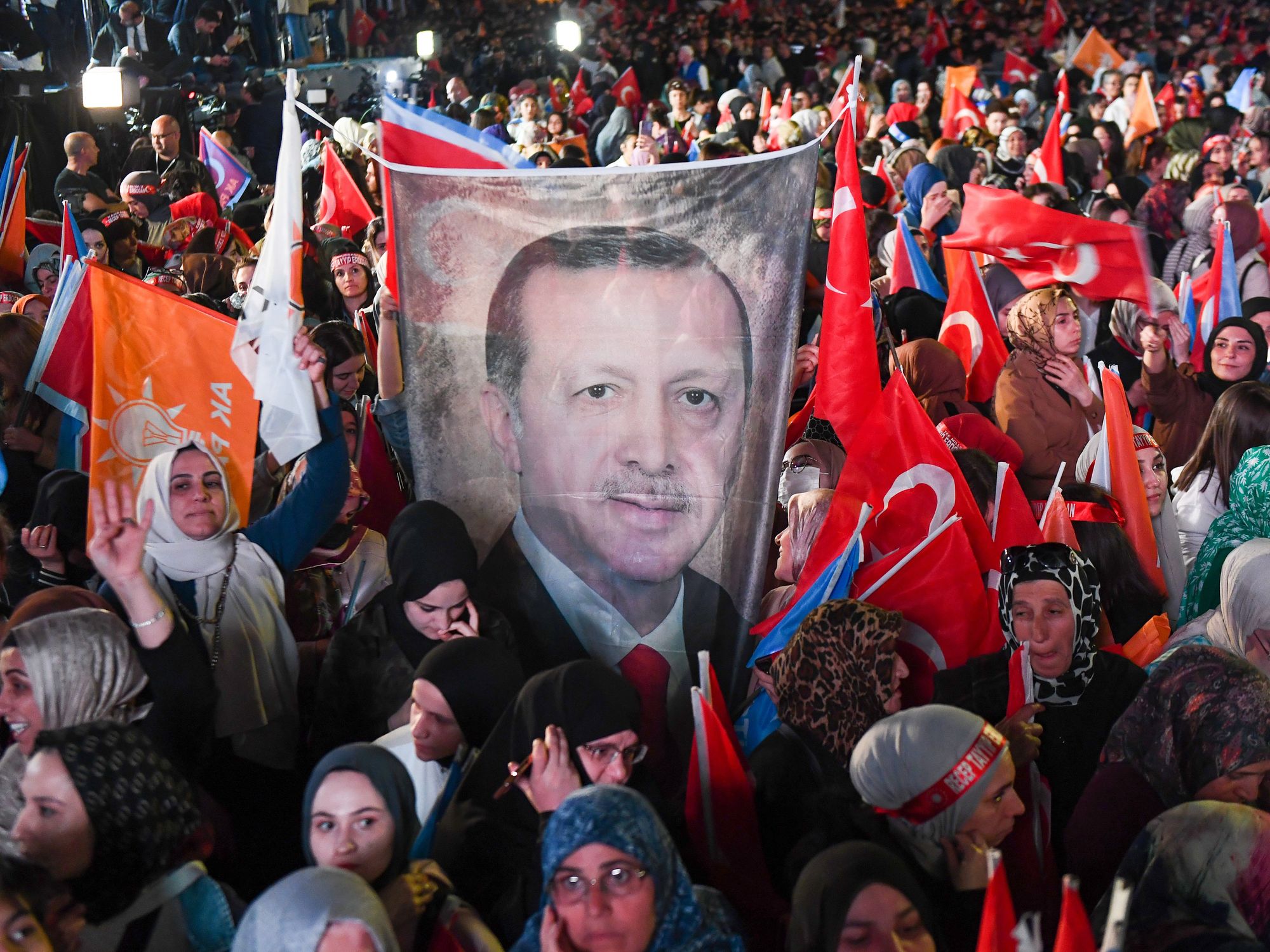 Image of people holding a flag with Erdogan's face on it during a protest in Ankara, Turkey.