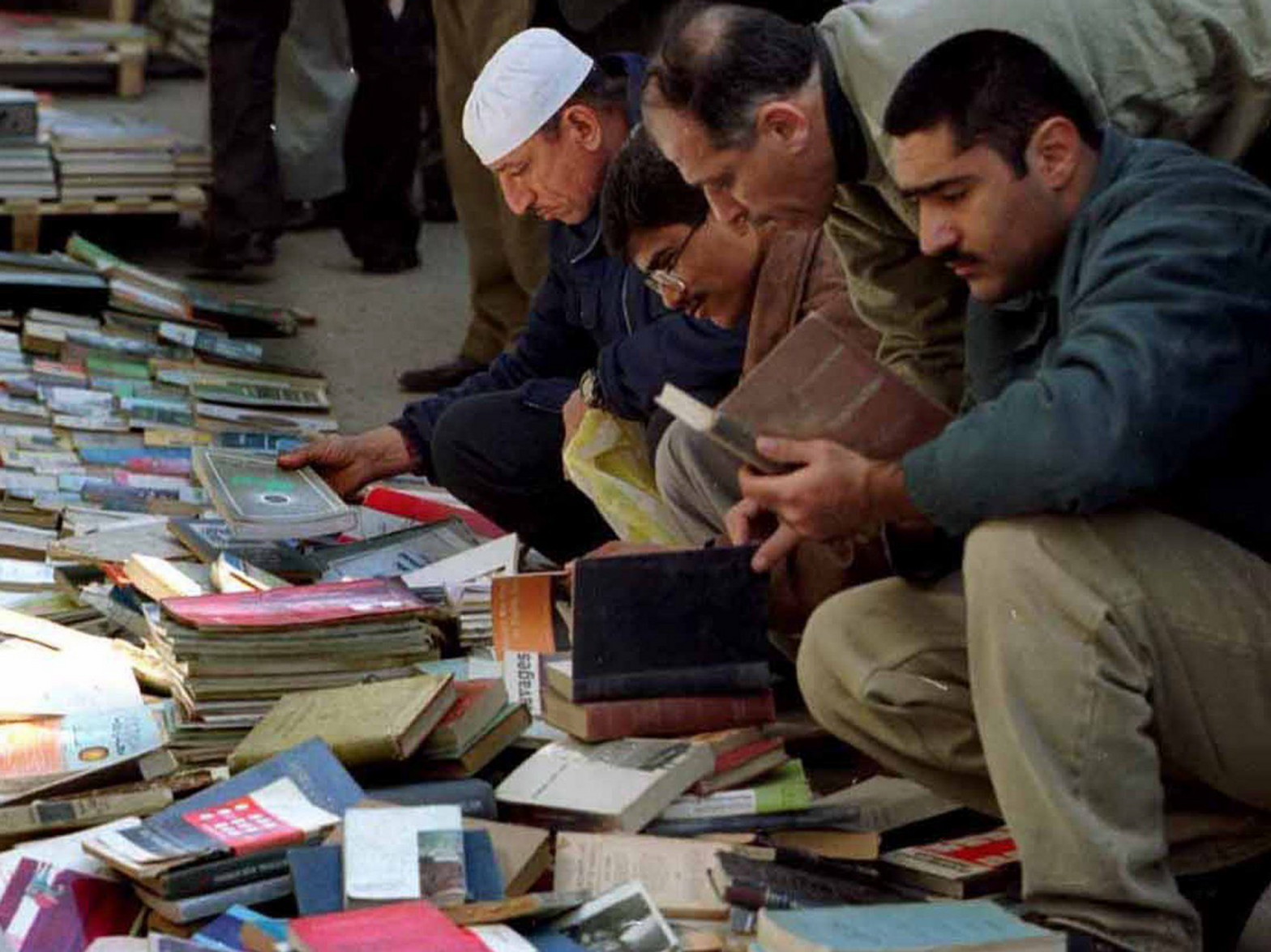 Image of people looking through books in a book market in the street.