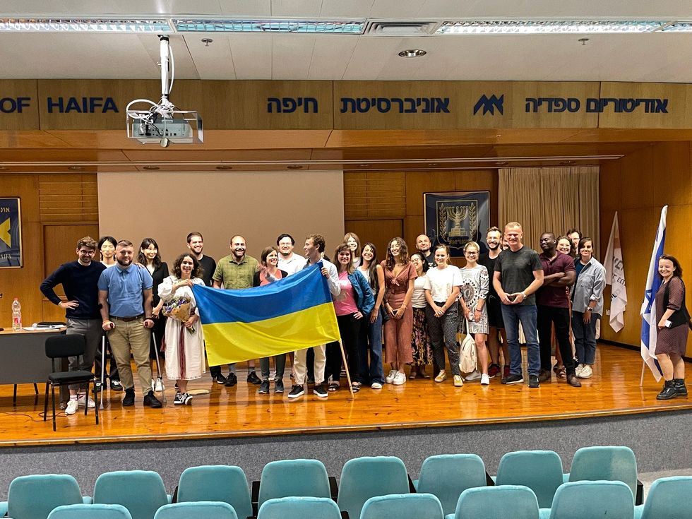 image of people on a stage holding a Ukrainian flag and an Israeli flag
