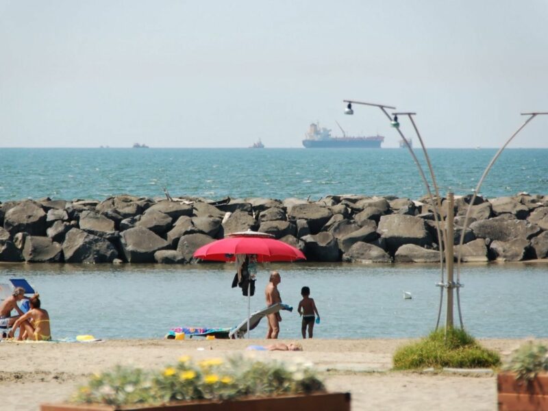 Image of people on the beach, with the sea in the background, in the city of Fiumicino.
