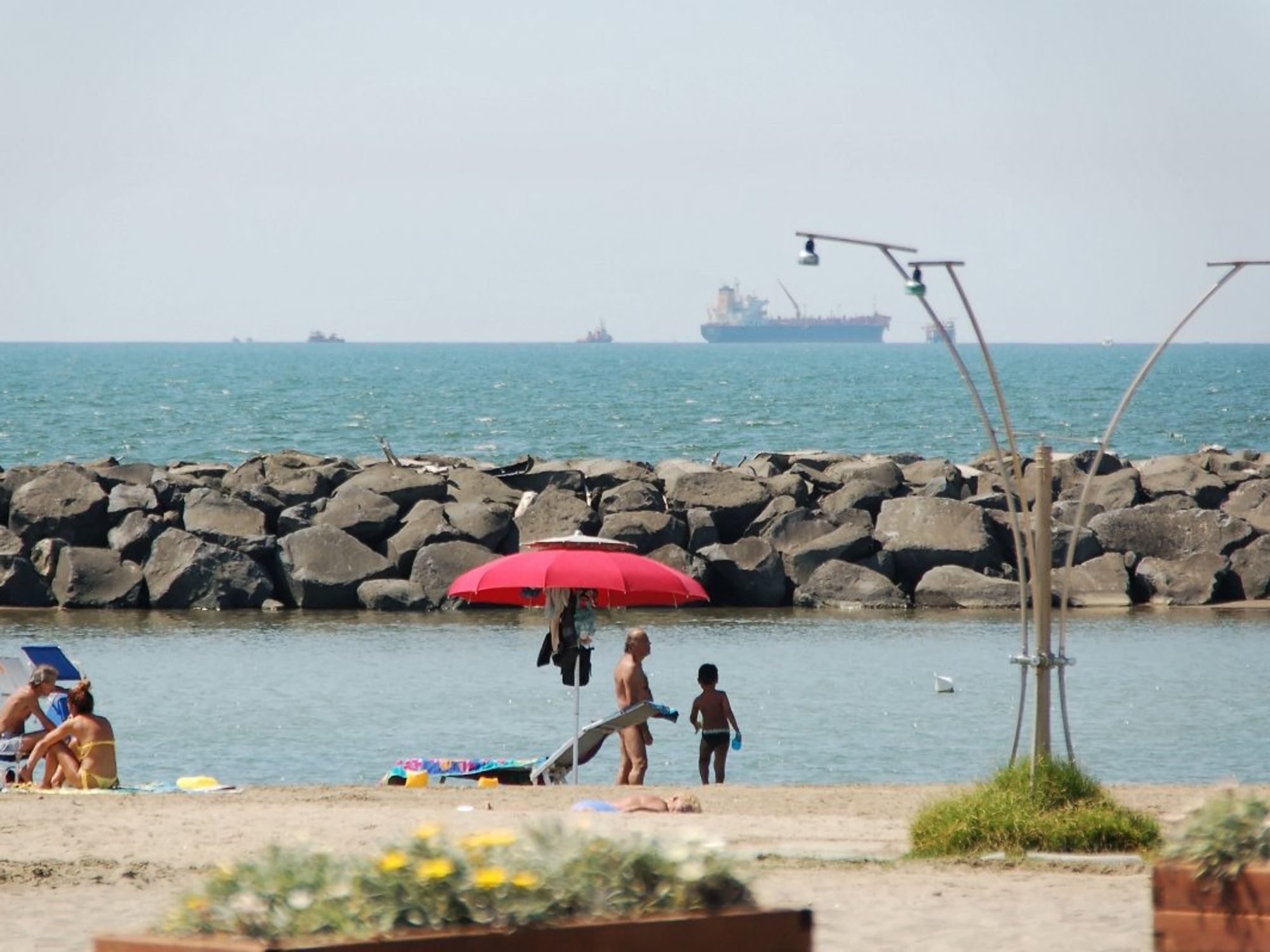 Image of people on the beach, with the sea in the background, in the city of Fiumicino.
