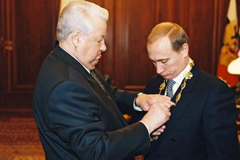 Image of president Boris Yeltsin handing the Presidential Emblem to Vladimir Putin.