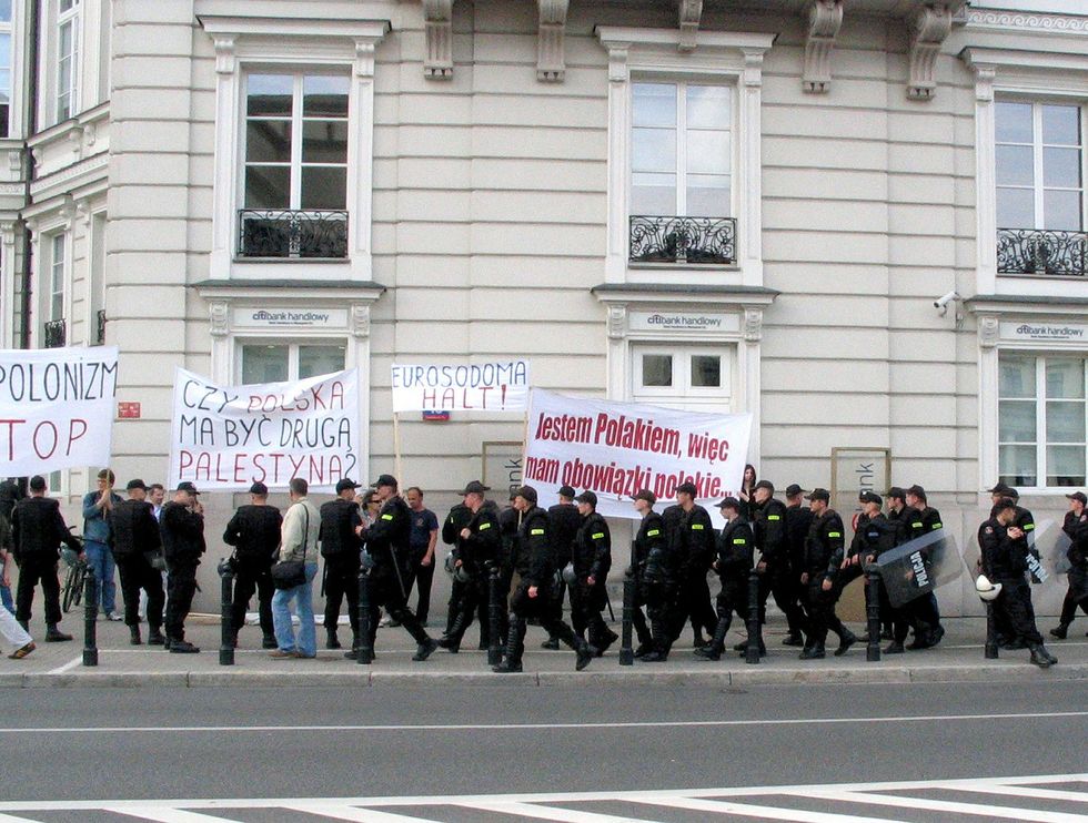 image of Równości parade in Warsaw 2006: Anti-gay demonstrators, separated by police forces. Writings on posters say: "Polonism top" (probably "Antipolonism stop"), "Does Poland have to be a second Palestine?", "Stop the eurosodom!" and "I'm Polish, so I have Polish duties".