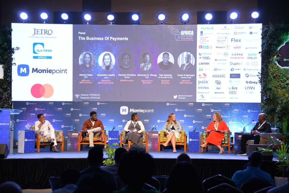 Image of six people sitting in front of an audience, talking during a Summit.