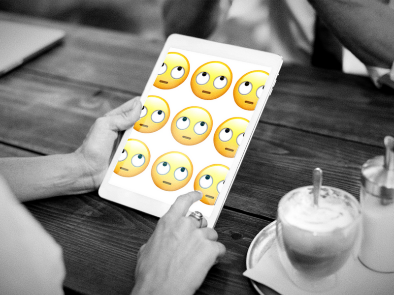 Image of someone looking at an eye rolling emoji on an ipad.