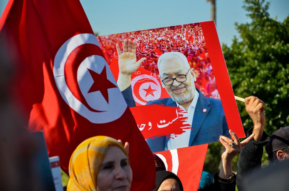 Image of supporters of the Ennahda movement outside of the anti-terrorism Judicial pole in Tunis, Tunisia, holding banners and tunisian flags.