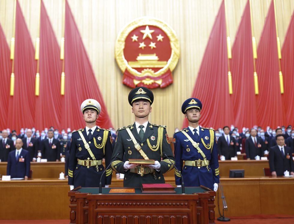 Image of The guard of honor of the Chinese People's Liberation Army (PLA) carries a copy of the country's Constitution during the ceremony for newly elected Chinese leader Xi Jinping.