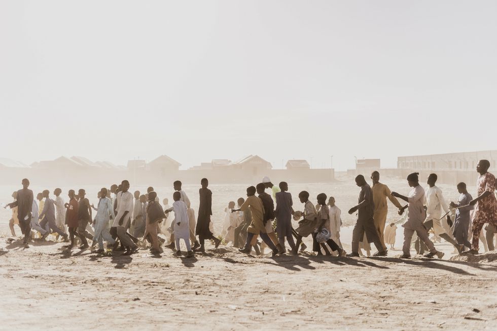 Image of the inhabitants of Ngarannam village walking in a sandy area