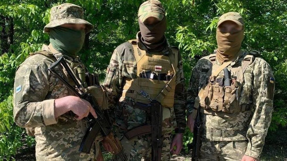 Image of three armed and masked military men in uniform.