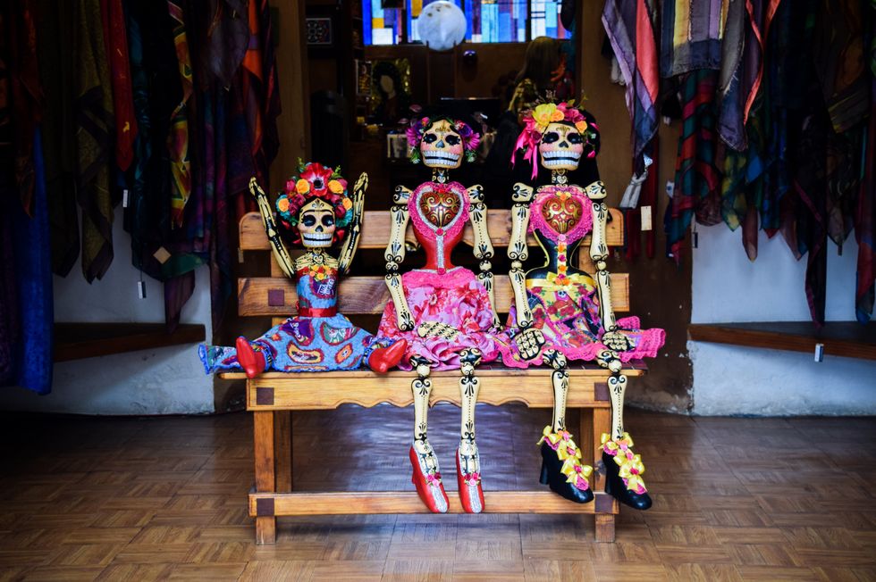 Image of three skeletons in costumes for El Dia de Los Muertos.