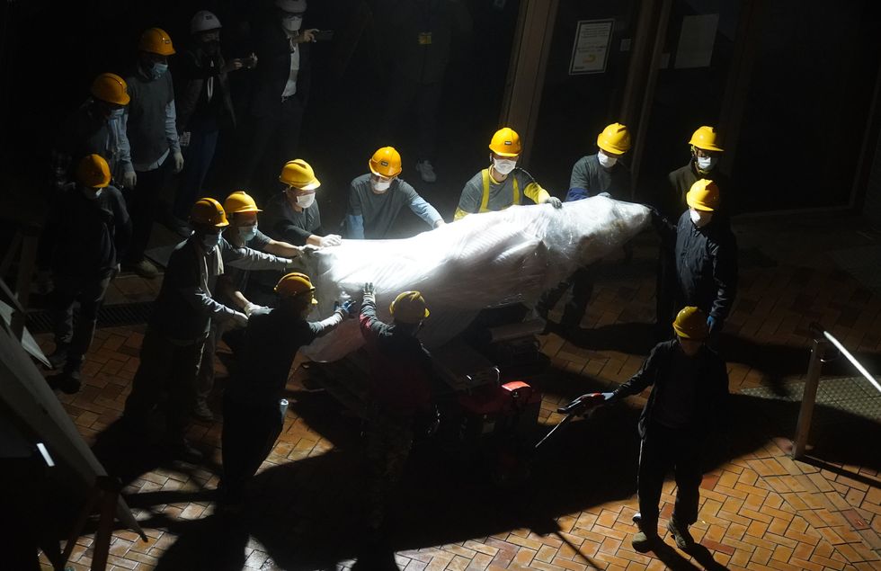 Image of workers removing The Pillar of Shame sculpture at University of Hong Kong, China.