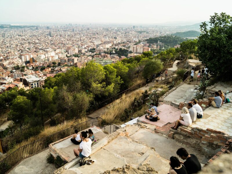 image showing people sitting on a hill, overlooking an urban landscape