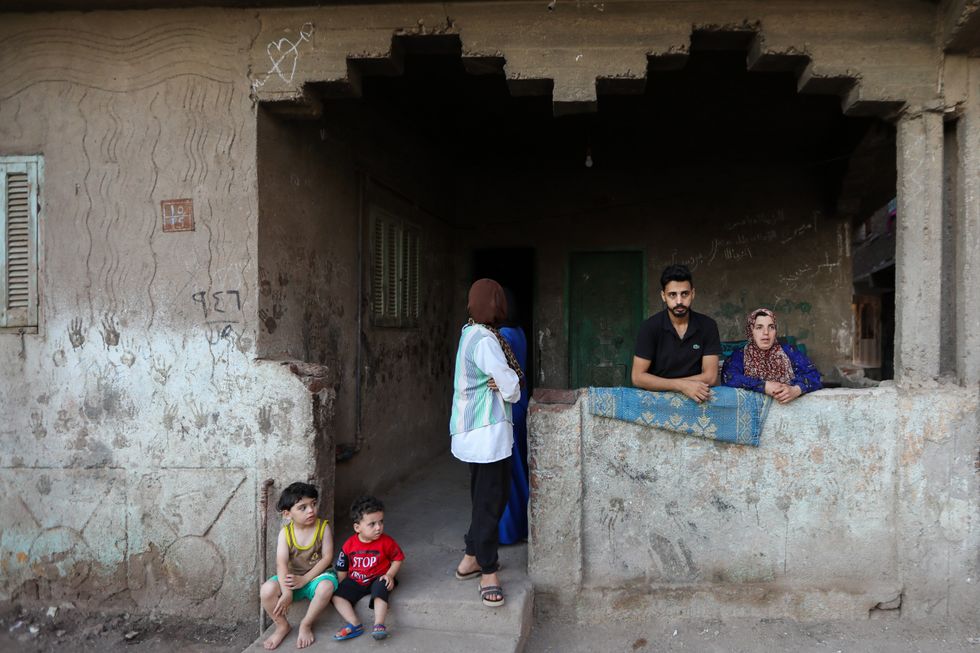 image showing the family of Abdullah Mahmoud Al-Sayed and Muhammad Ahmed Al-Sayed stand in front of their home.