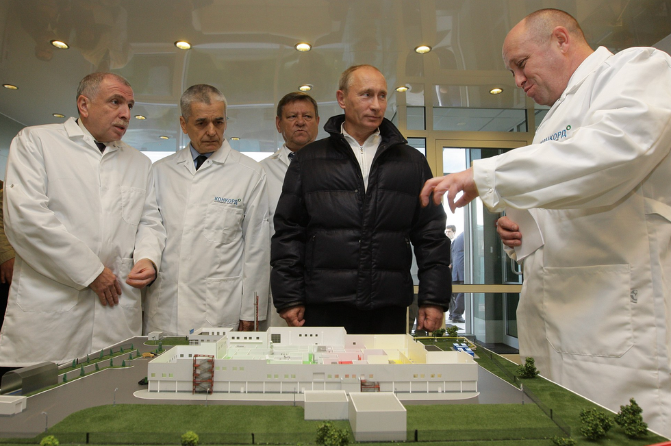 Image showing Vladimir Putin looking over a factory's production chain with the factory's director, Yevgeny Prigozhin.