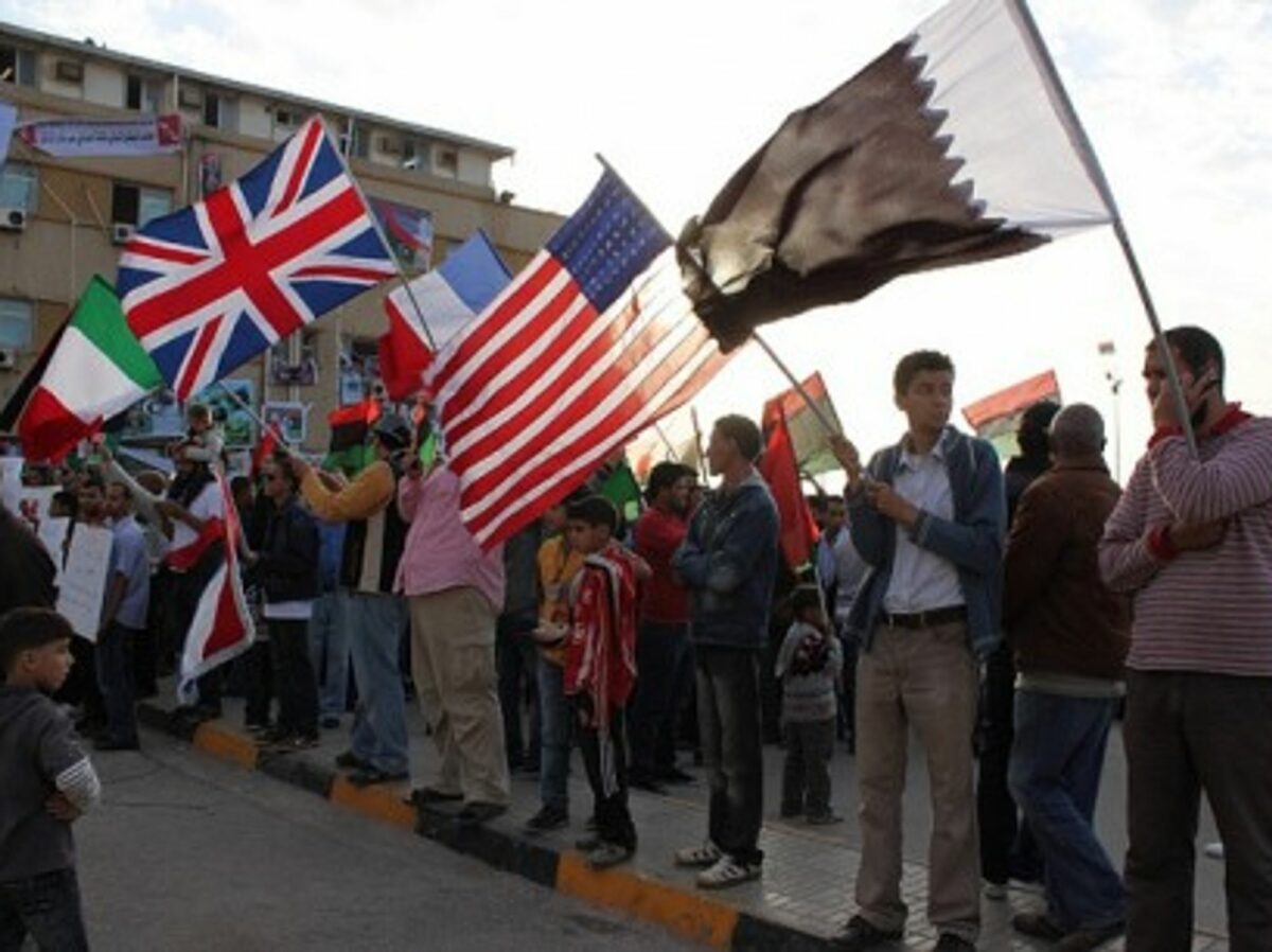 In Benghazi, people holding the Qatari, American, French, British and Italian flags