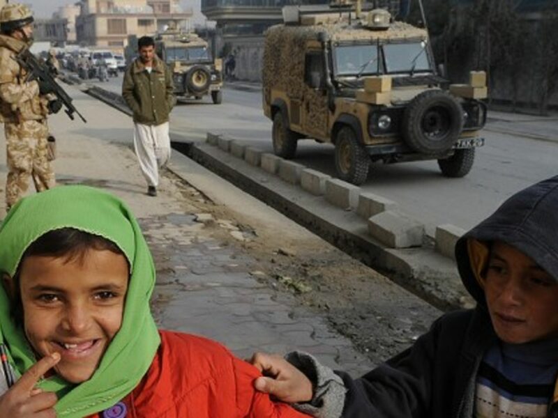 In Kabul, children play as British military vehicles pass (isafmedia)